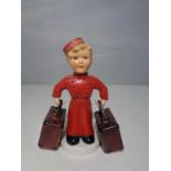 A GOEBEL FIGURINE OF A BELLHOP BOY AND SUITCASES
