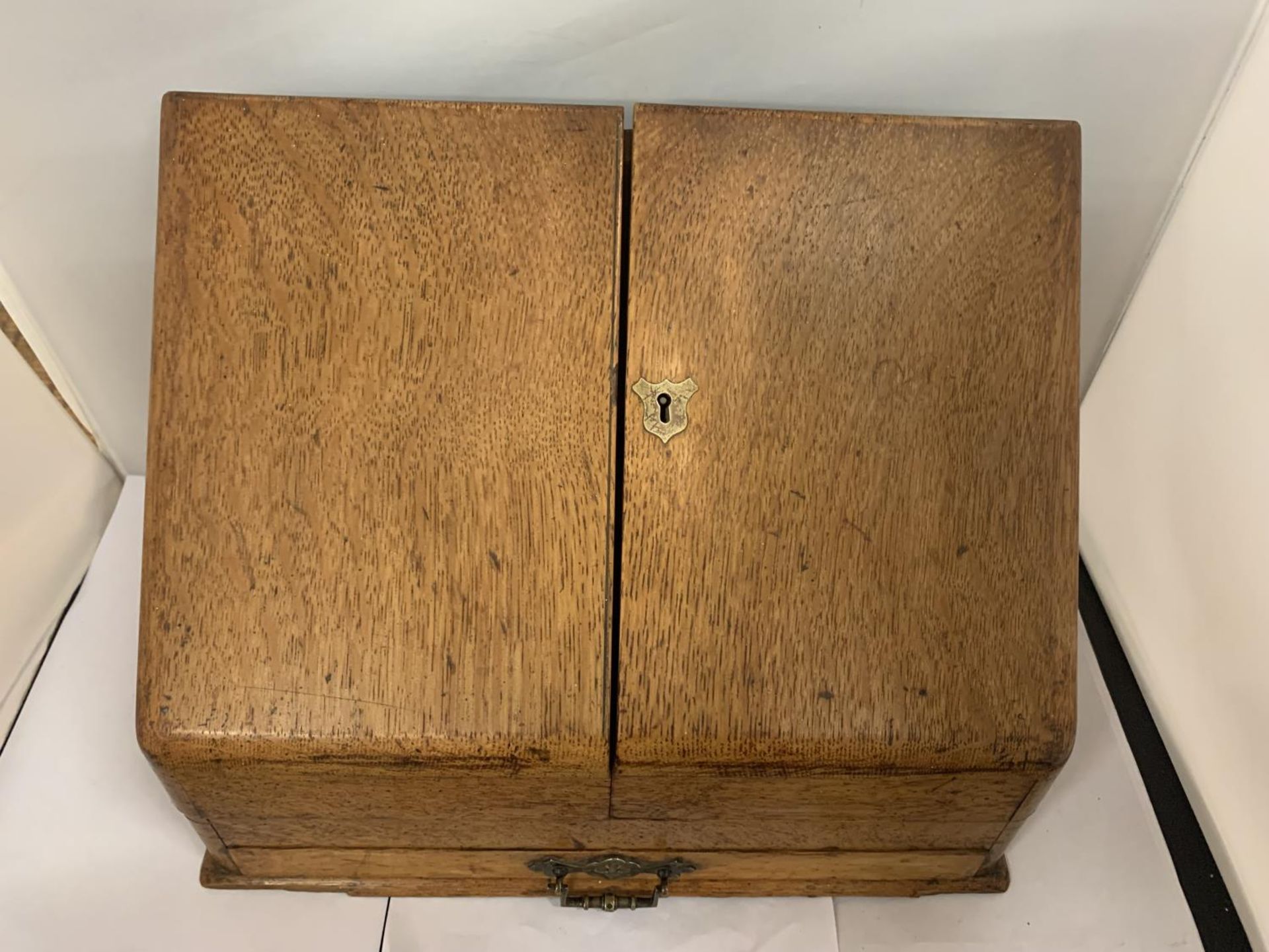 A VINTAGE OAK DESK TIDY WITH TWO DOORS AND A LOWER DRAW