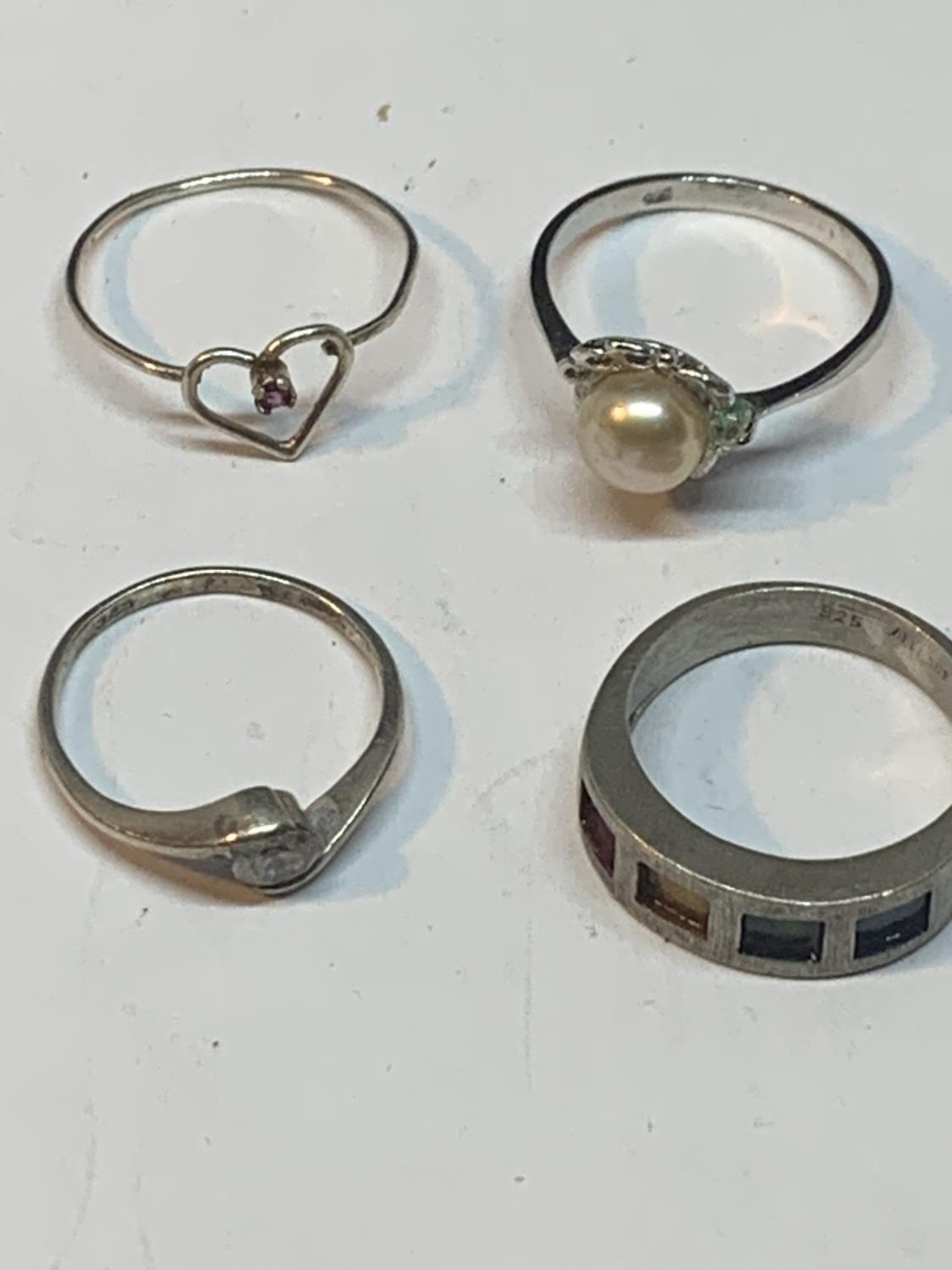 FOUR SILVER RINGS TO INCLUDE A HEART DESIGN, PEARL, COLOURED STONE BAND ETC