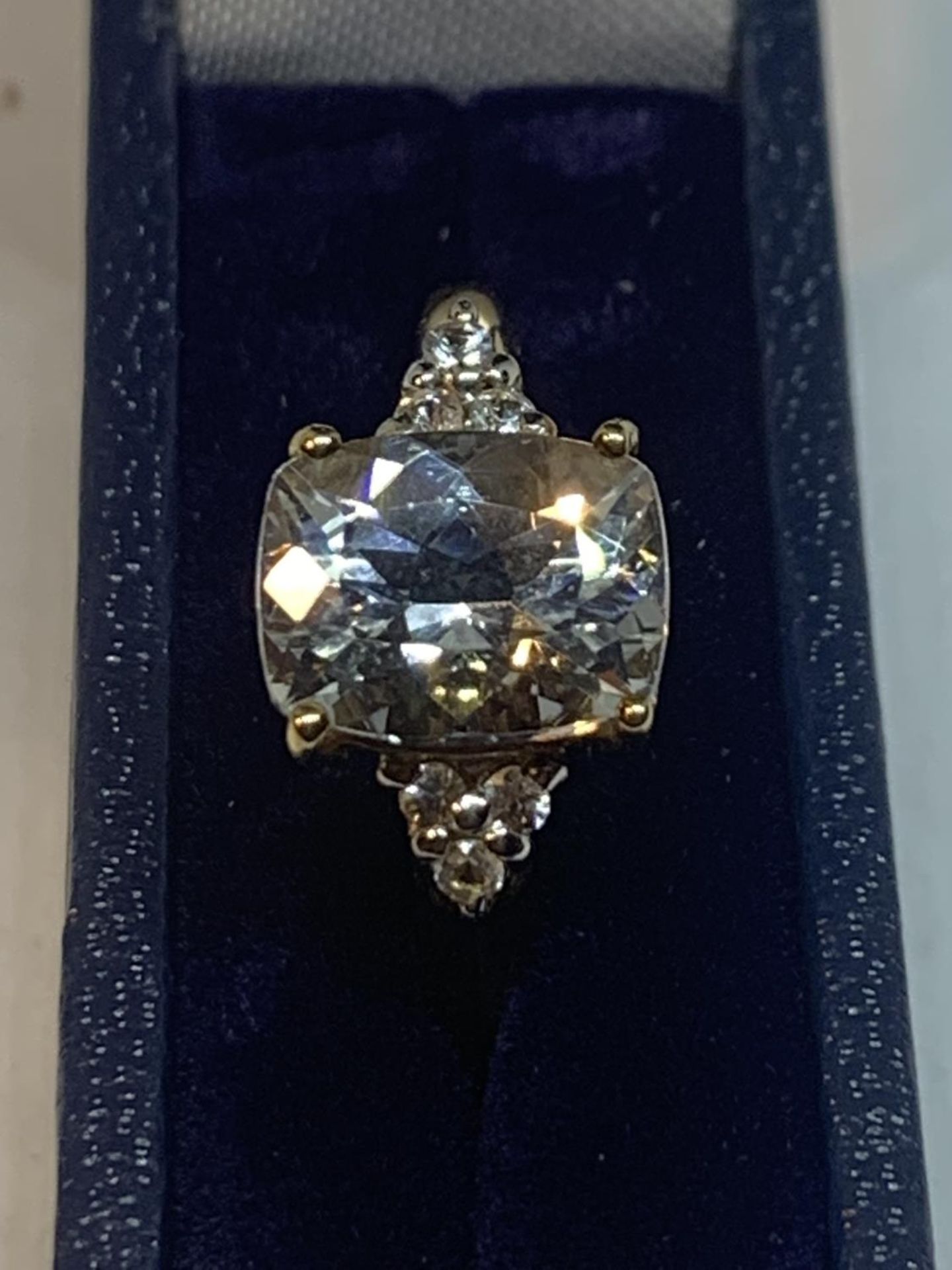 A 9 CARAT GOLD RING WITH A LARGE CENTRE STONE AND CHIPS TO THE SHOULDERS IN A PRESENTATION BOX