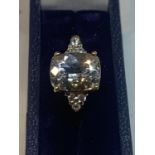 A 9 CARAT GOLD RING WITH A LARGE CENTRE STONE AND CHIPS TO THE SHOULDERS IN A PRESENTATION BOX