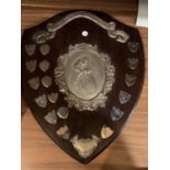 A VINTAGE LARGE WOODEN CYCLING SHIELD DEPICTING THE WINNERS OF THE LES SALMON SHIELD GLOSSOP VELO