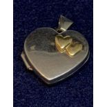 A 9 CARAT WHITE GOLD HEART SHAPED LOCKET WITH A DOUBLE HEART YELLOW GOLD DECORATION IN A