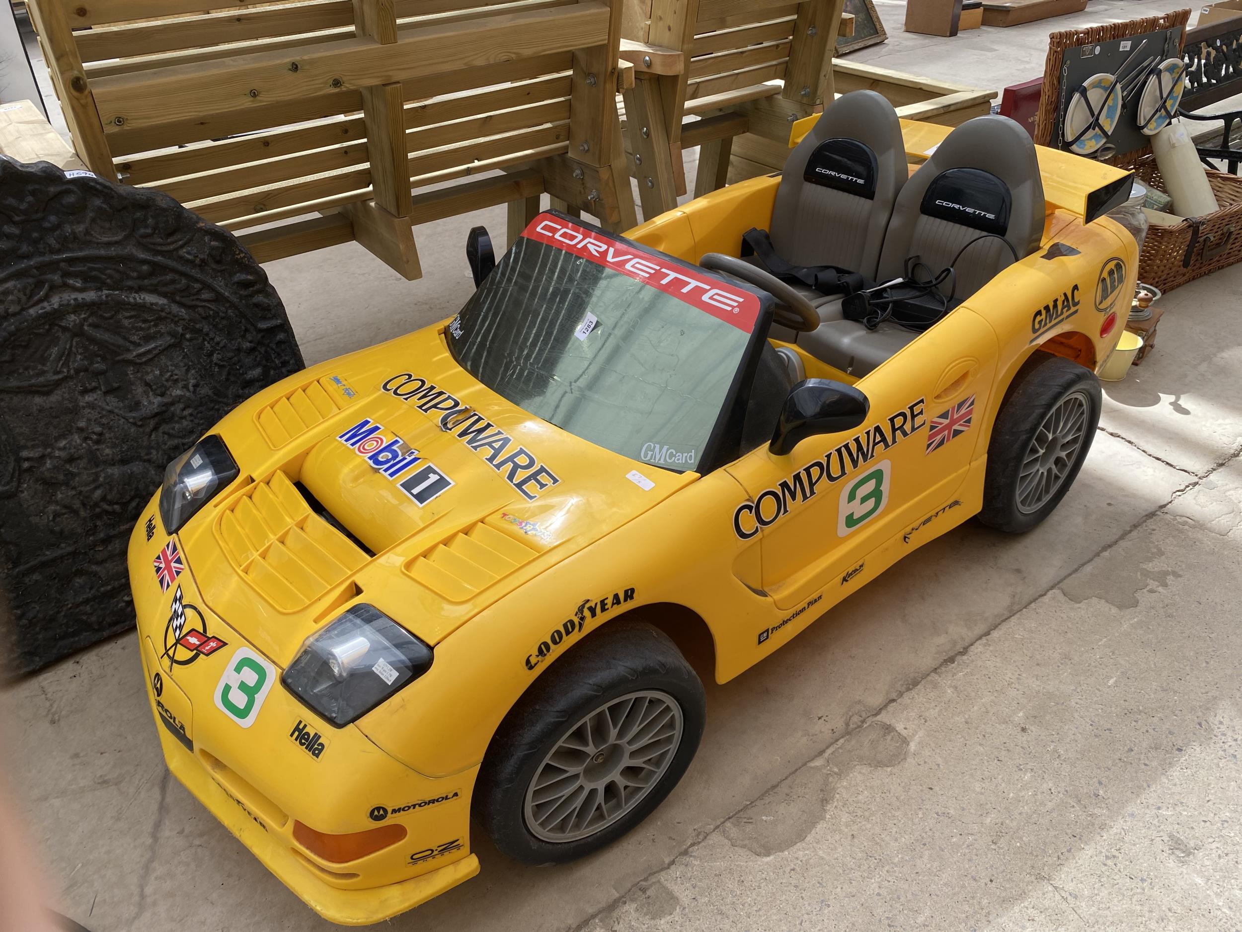 A CHILDRENS BATTERY POWERED RIDE ON CORVETTE CAR WITH CHARGER