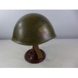 A GREEN PAINTED METAL MILITARY HELMET WITH SS DECAL AND LEATHER LINING
