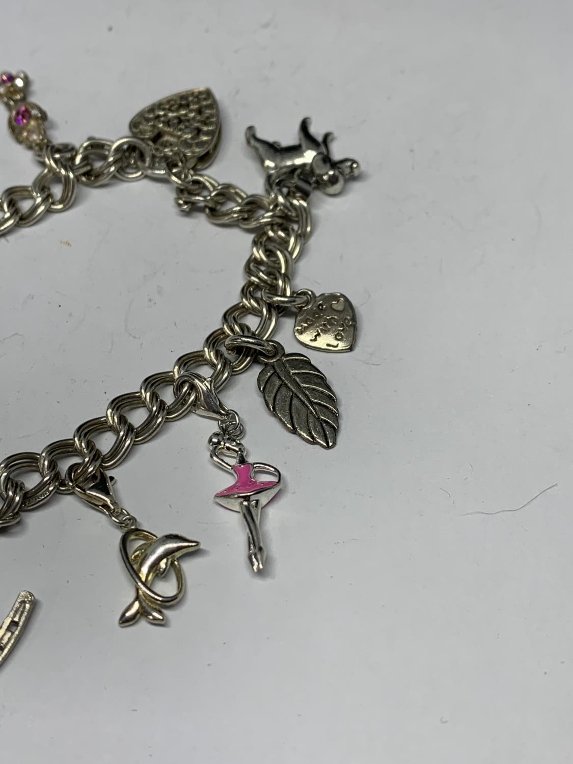 A SILVER CHARM BRACELET WITH ELEVEN CHARMS TO INCLUDE A BALLERINA, BALLET SHOES, DOG ETC - Bild 3 aus 3