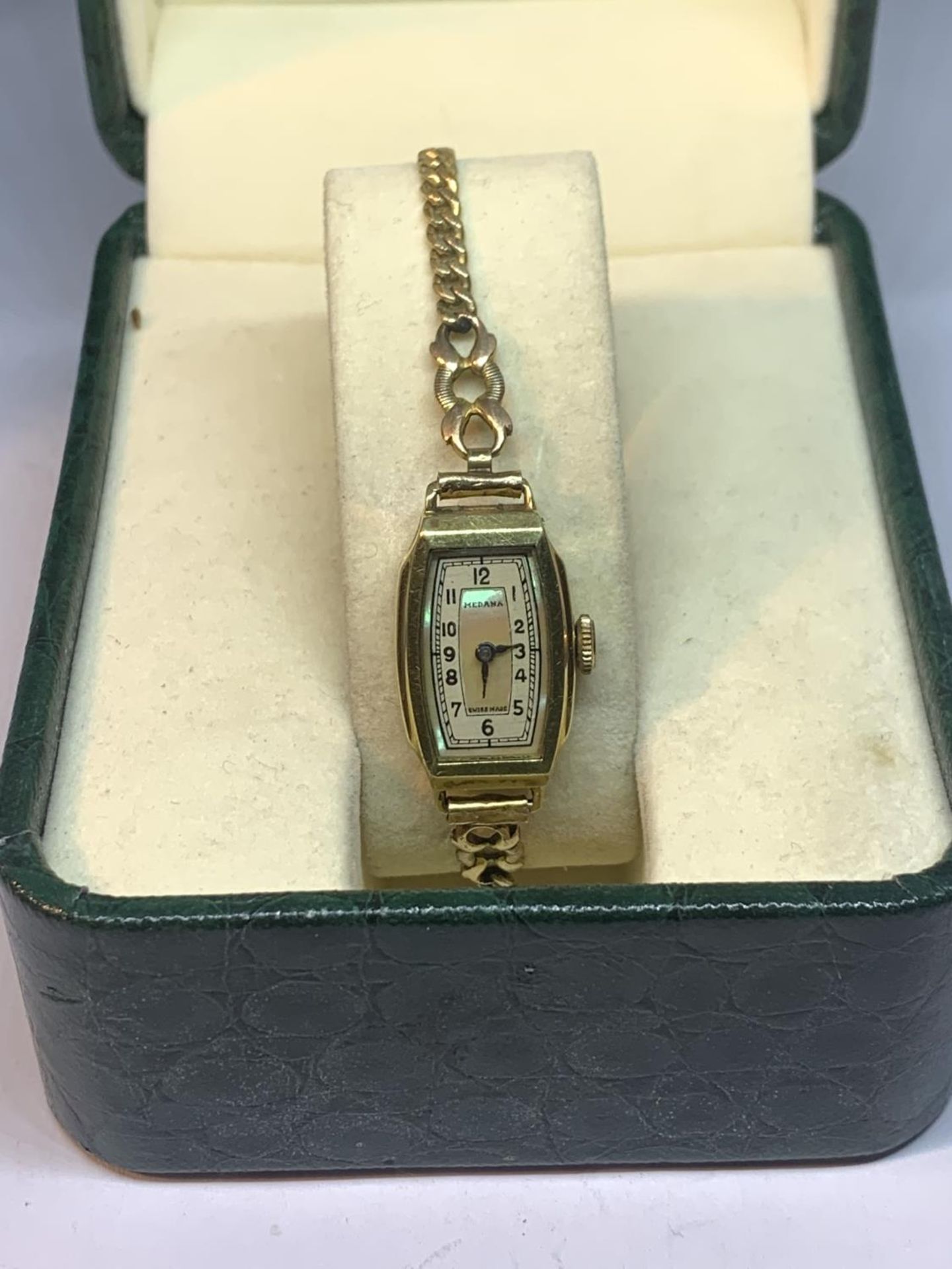 A YELLOW METAL WRISTWATCH WITH PEARLISED RECTANGUALR STYLE FACE IN A PRESENTATION BOX