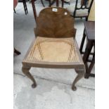 AN EARLY 20TH CENTURY WALNUT STOOL WITH A CANE SEAT AND A HIGH BACK ON CABRIOLE LEGS