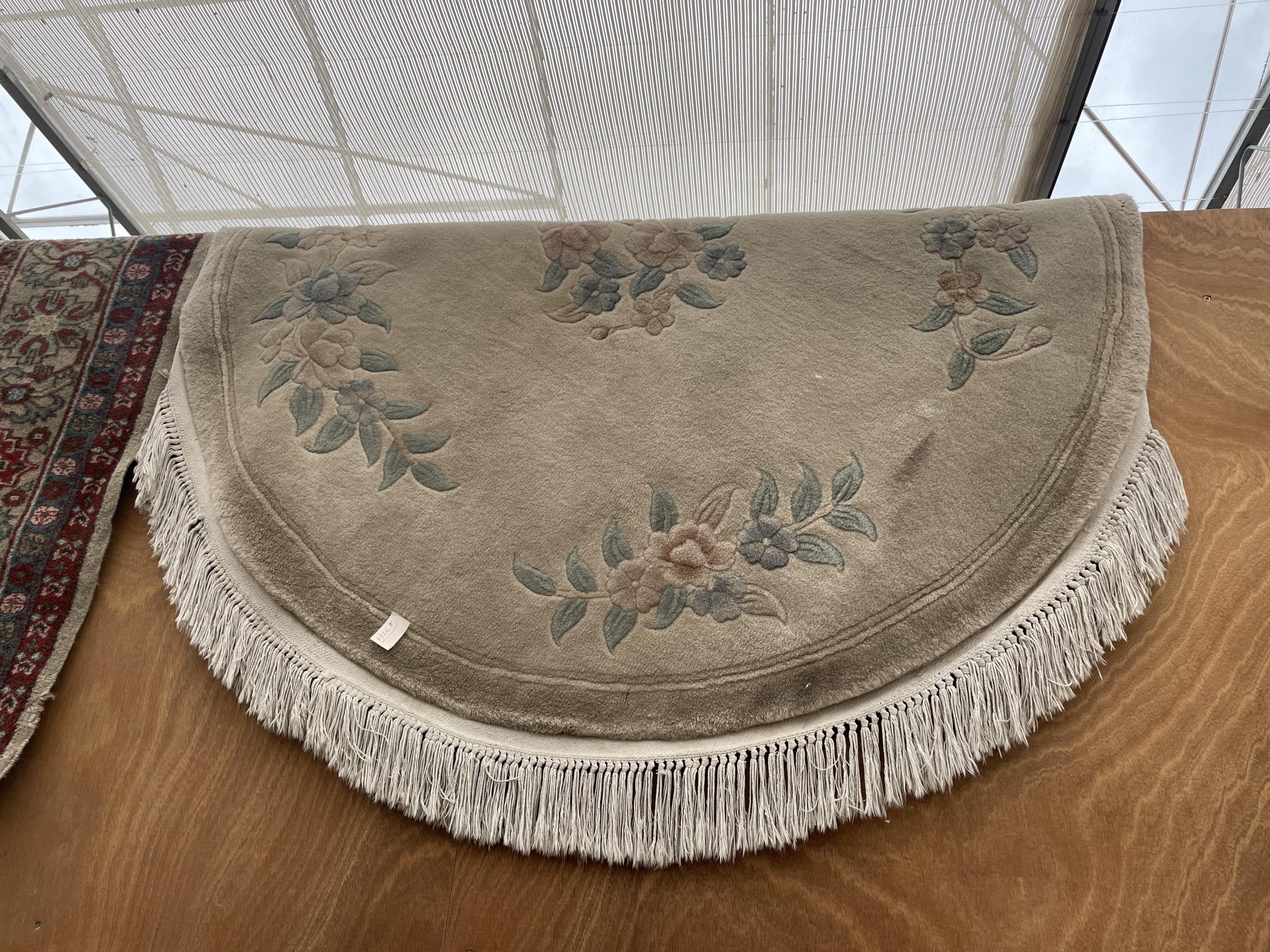 AN OVAL CREAM PATTERENED FRINGED RUG