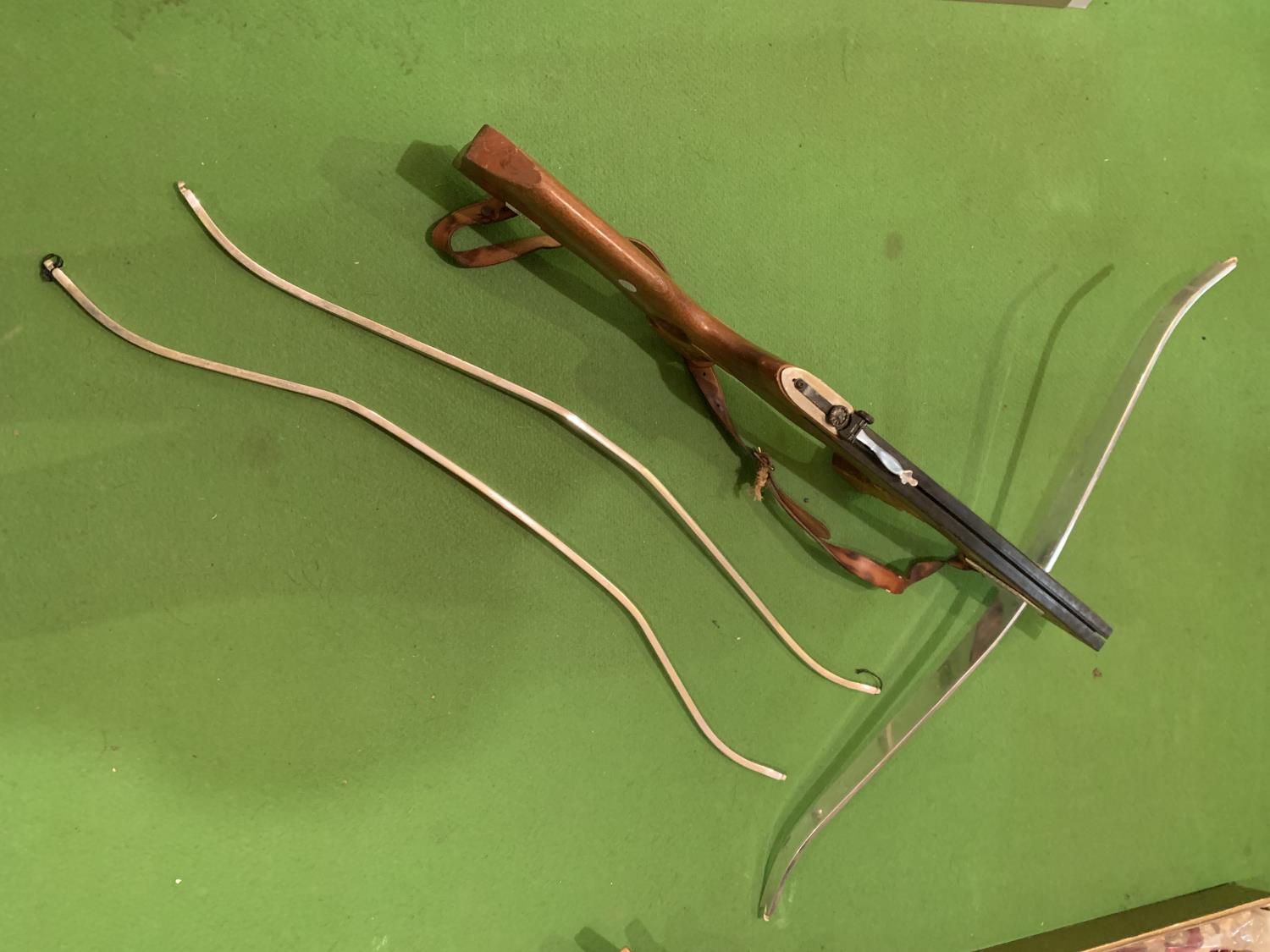 A CROSSBOW WITH WOODEN STOCK AND THREE METAL BOWS