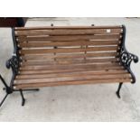 A WOODEN SLATTED GARDEN BENCH WITH CAST BENCH ENDS