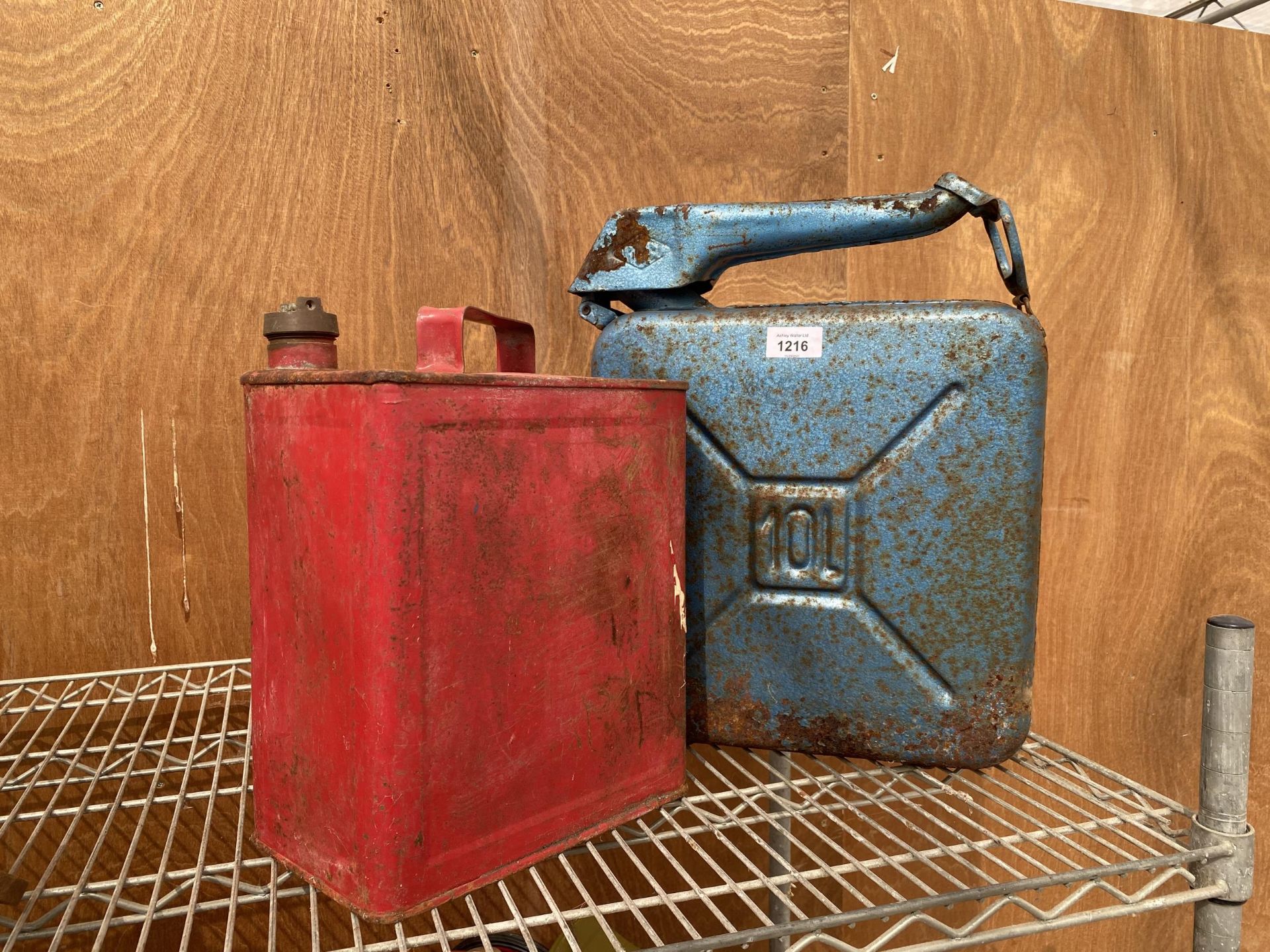 A VINTAGE RED FUEL CAN WITH BRASS TOP AND A FURTHER BLUE FUEL CAN