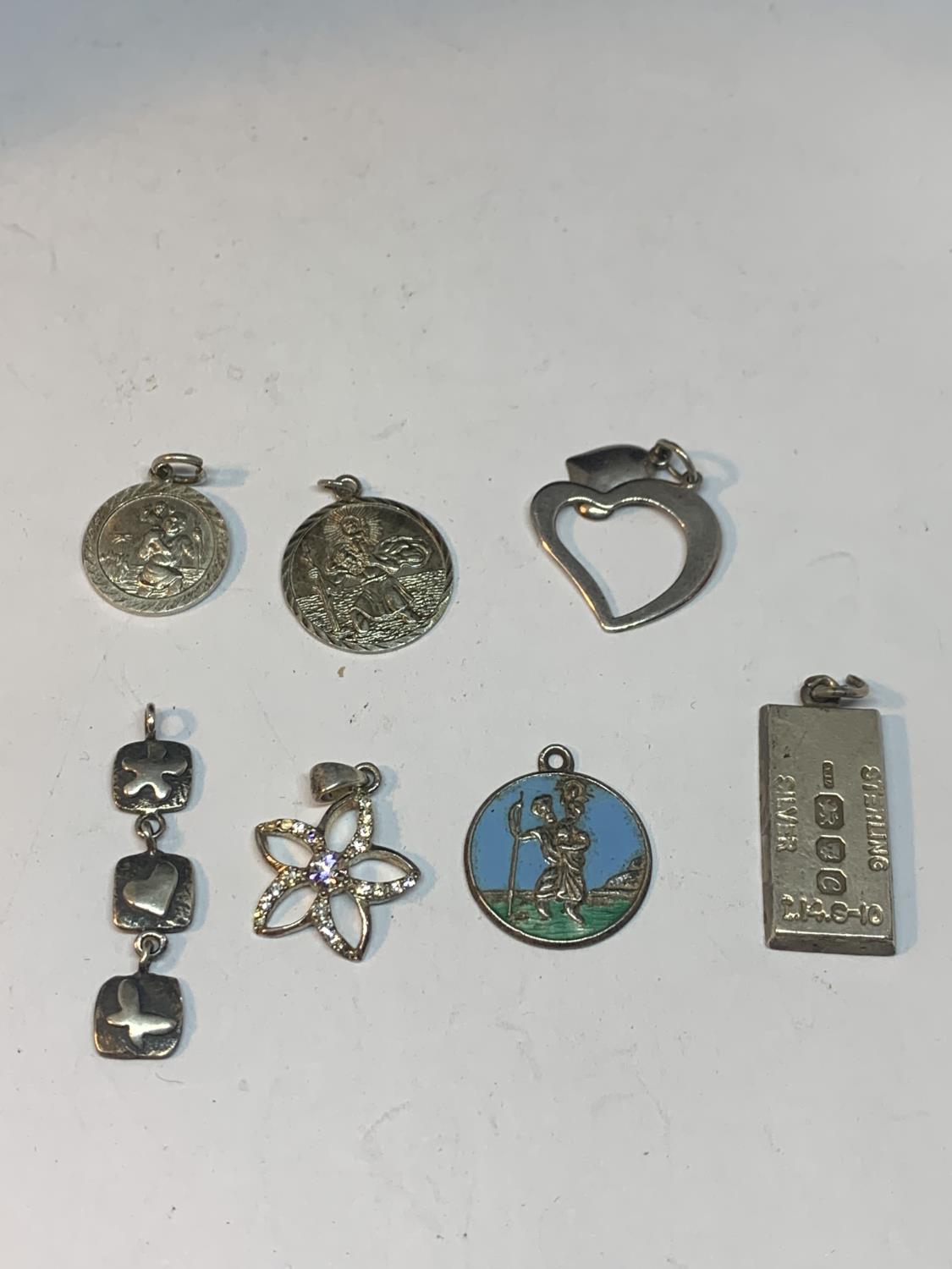 SEVEN SILVER PENDANTS TO INCLUDE ST CHRISTOPHERS, FLOWER DESIGN, HEART AND INGOT ETC