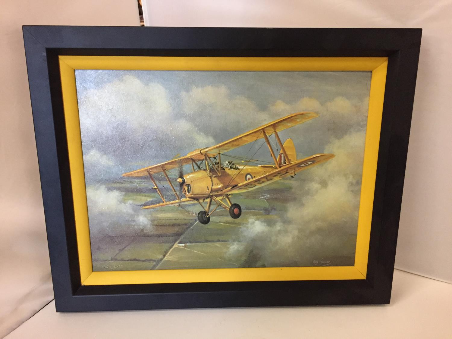 A FRAMED COLOURED CANVAS PRINT OF A BIPLANE