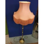 A BRASS STANDARD LAMP WITH PINK SHADE