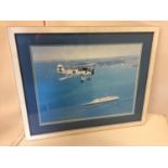 A FRAMED COLOURED PICTURE OF A SWORDFISH PLANE FLYING OVER A CRUISE SHIP 30CM X 40CM