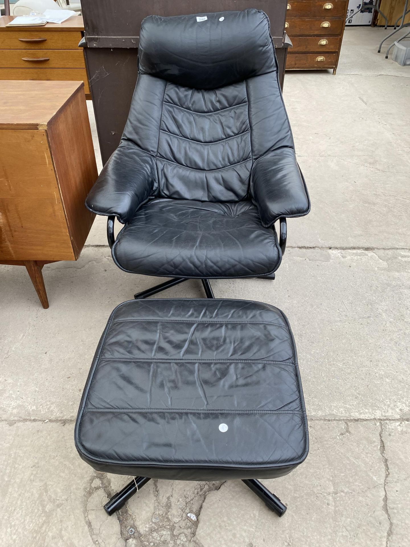 A MODERN FAUX BLACK LEATHER ADJUSTABLE EASY CHAIR AND MATCHING STOOL