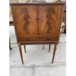 A RETRO MAHOGANY COCKTAIL CABINET WITH A GLASS SLIDER LABELLED PAYNE AND HOLDER (WESTON-SUPER-MARE)