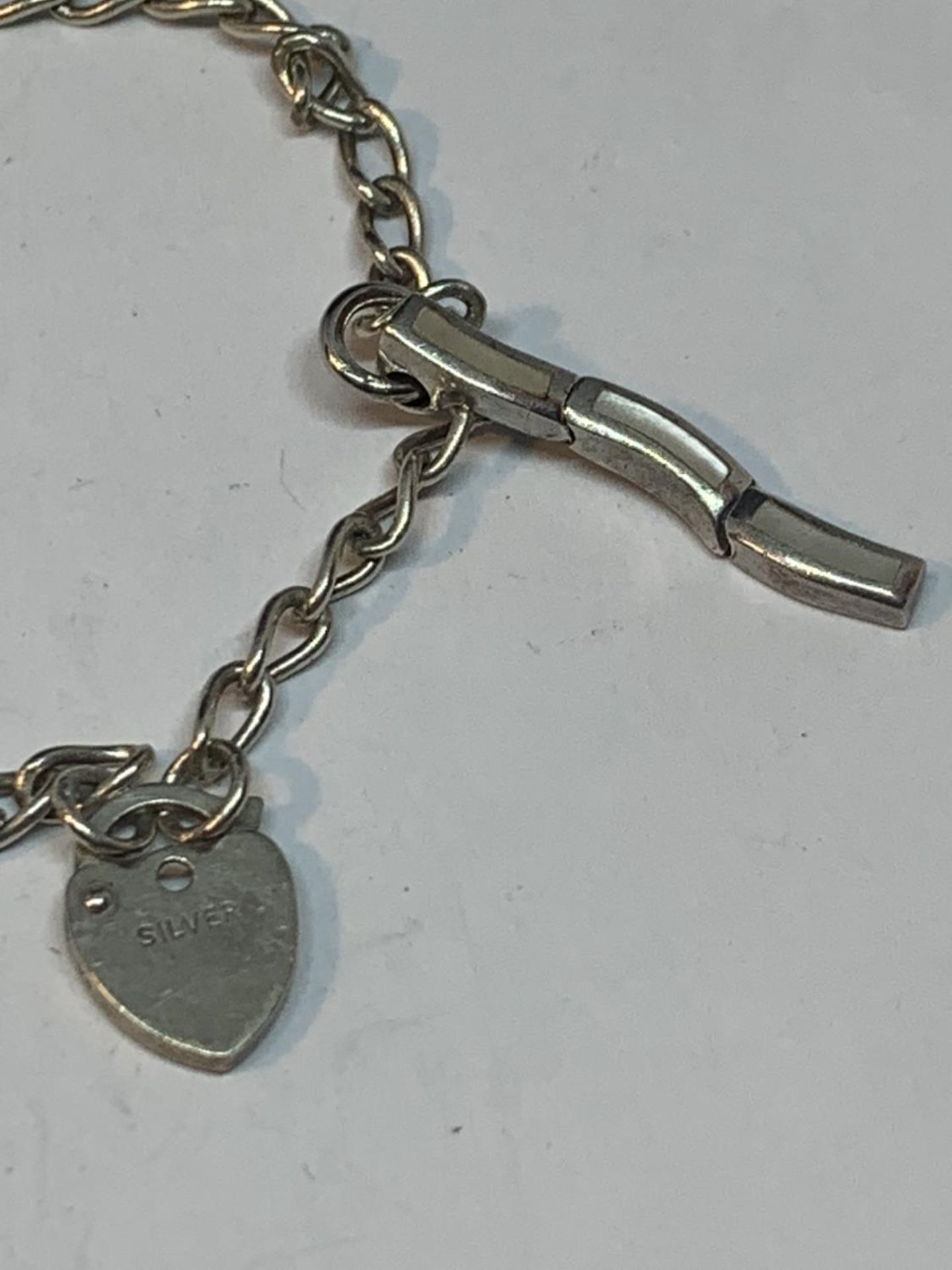 A SILVER BRACELET WITH THREE CHARMS AND A HEART PADLOCK - Image 4 of 5