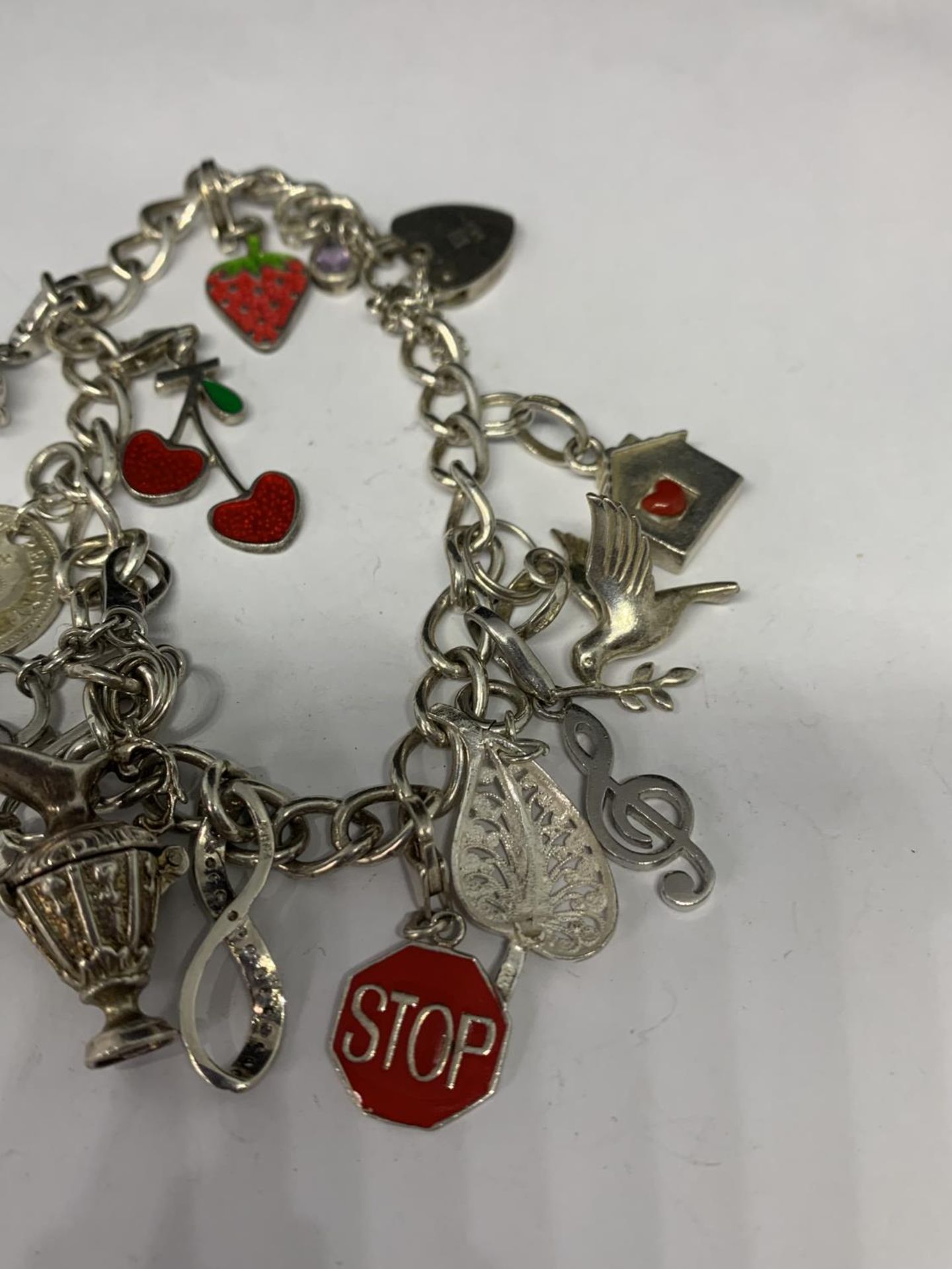 A HEAVY SILVER CHARM BRACELET WITH THIRTEEN CHARMS TO INCLUDE A STRAWBERRY, CHERRIES, DOVE ETC - Image 4 of 4