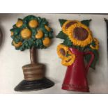 TWO CAST IRON DOOR STOPS TO INCLUDE AN ORANGE TREE AND A SUNFLOWER DESIGN