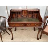 A CHIPPENDALE STYLE WRITING BUREAU WITH THIRTEEN DRAWERS, SMALL CUPBOARD AND INSET LEATHER TOP ON