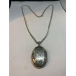 A SILVER NECKLACE WITH A LARGE OVAL LOCKET PENDANT