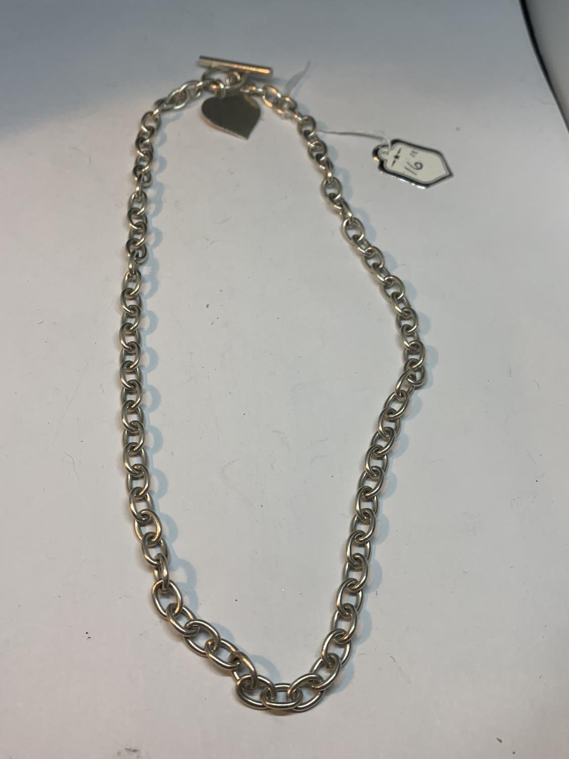 A SILVER NECKLACE WITH HEART PENDANT 16 INCHES LONG