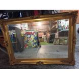 A LARGE ORNATE GILT FRAMED MIRROR 87CM X63CM