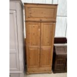 A MODERN PINE TWO DOOR WARDROBE WITH A DRAWER TO THE BASE AND TOP BOX 35" WIDE