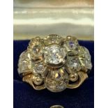 AN 18 CARAT WHITE AND YELLOW GOLD ART DECO CLUSTER RING WITH A CENTRE DIAMOND, SIX SURROUNDING