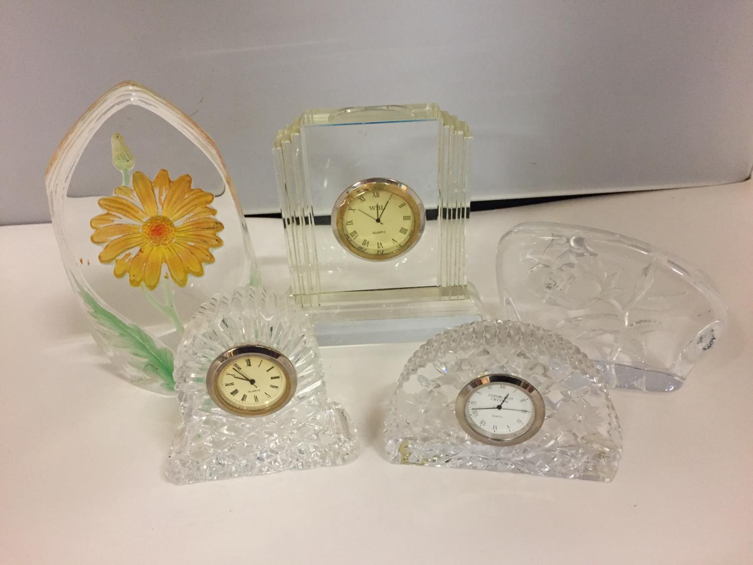 A NUMBER OF CUT GLASS ITEMS TO INCLUDE THREE SMALL CLOCKS AND TWO PAPER WEIGHTS