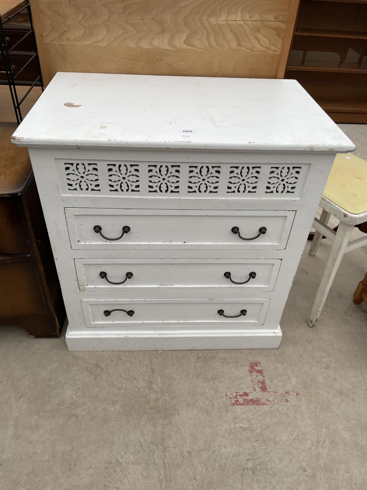 A WHITE PAINTED CHEST OF THREE DRAWERS WITH PIERCED FRETWORK FRONT - 30" WIDE