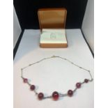 A 9 CARAT GOLD WIRE AND RED STONE NECKLACE IN A PRESENTATION BOX