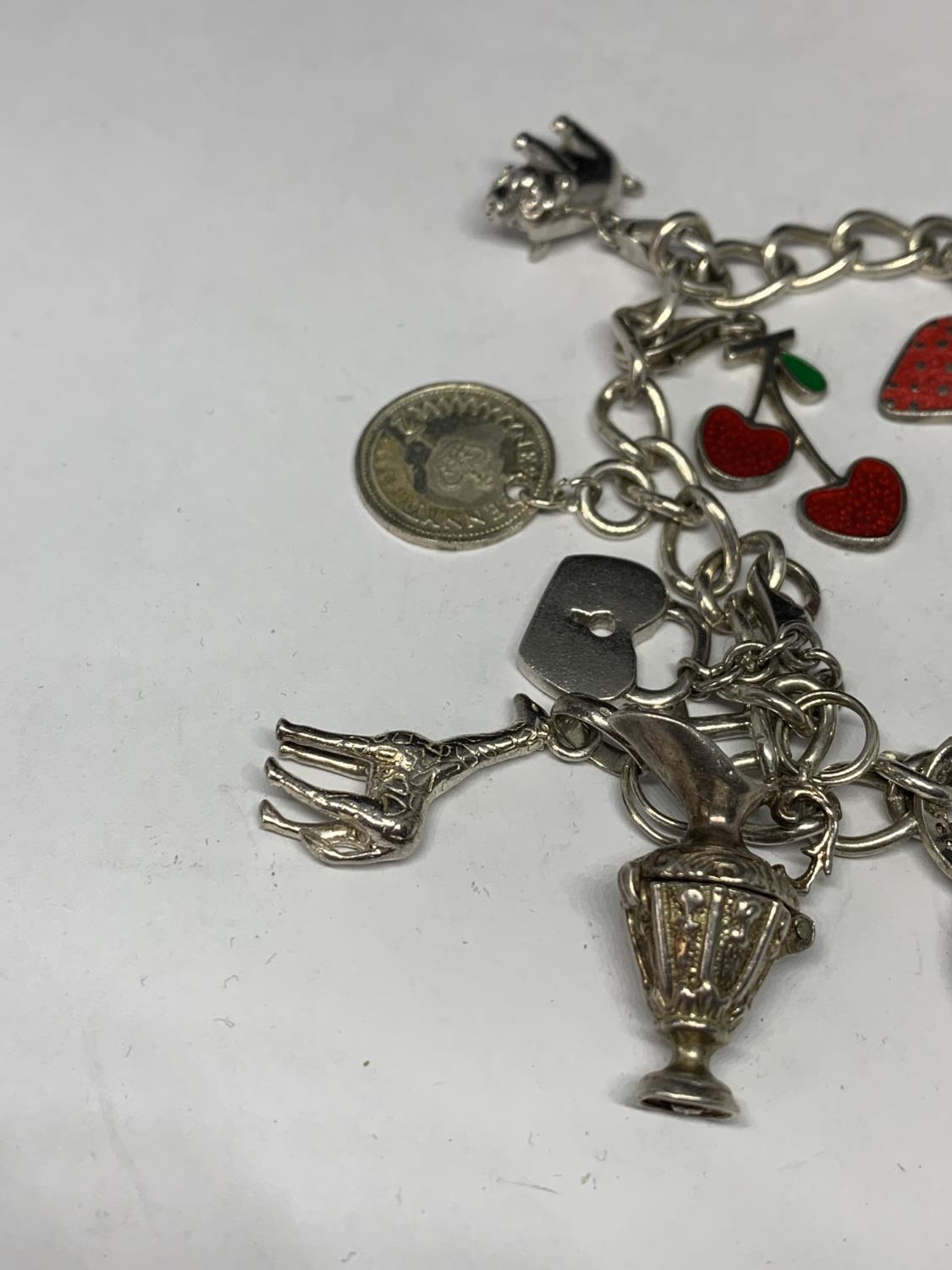 A HEAVY SILVER CHARM BRACELET WITH THIRTEEN CHARMS TO INCLUDE A STRAWBERRY, CHERRIES, DOVE ETC - Image 2 of 4