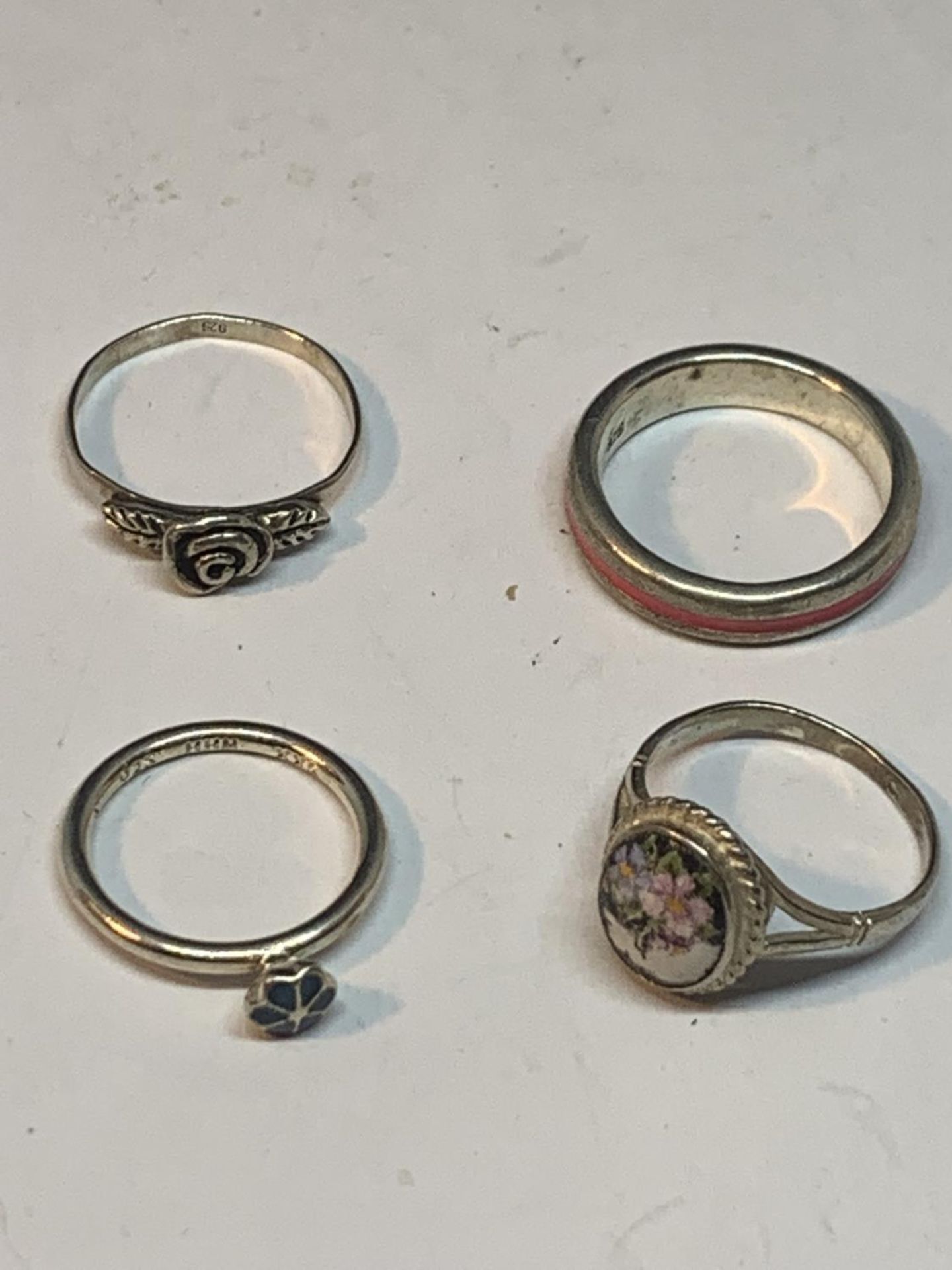 FOUR SILVER RINGS TO INCLUDE FLOWER DESIGNS