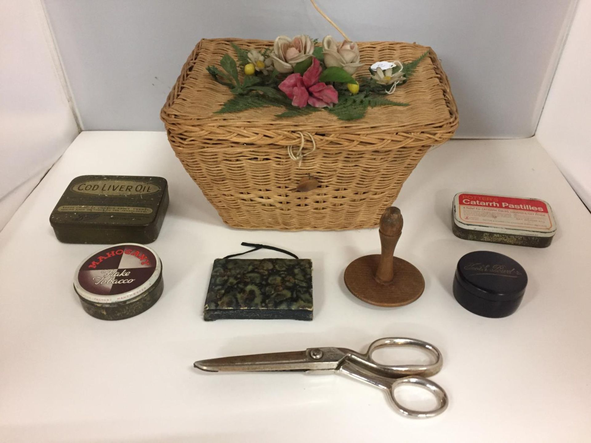 A SMALL VINTAGE SEWING BASKET CONTAINING VARIOUS SEWING ITEMS AND VINTAGE TINS