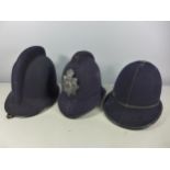 AN OLDHAM POLICE HELMET AND TWO FURTHER POLICE HELMETS (3)