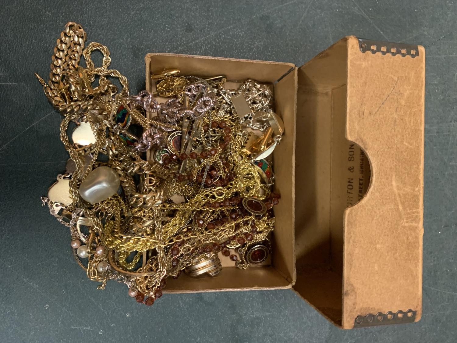 A LARGE QUANTITY OF YELLOW METAL COSTUME JEWELLERY IN A BOX