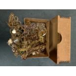 A LARGE QUANTITY OF YELLOW METAL COSTUME JEWELLERY IN A BOX