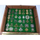 A GLAZED DISPLAY CASE CONTAINING THIRTY SEVEN BRITISH ARMY CAP BADGES, 34CM X 40CM
