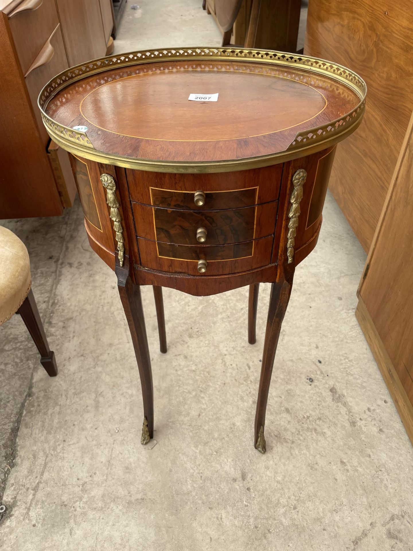 AN OVAL LOUIS XVI STYLE WALNUT SIDE TABLE WITH THREE SMALL DRAWERS, BRASS PIERCED GALLERY AND