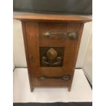AN ARTS AND CRAFTS CABINET WITH COPPER HINGES AND DECORATIVE PANEL (LOCKED WITH NO KEY)