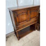 A GEORGIAN STYLE OAK TOW DOOR PANELLED CUPBOARD WITH SINGLE DRAW AND SLIDE, ON OPEN BASE, WITH