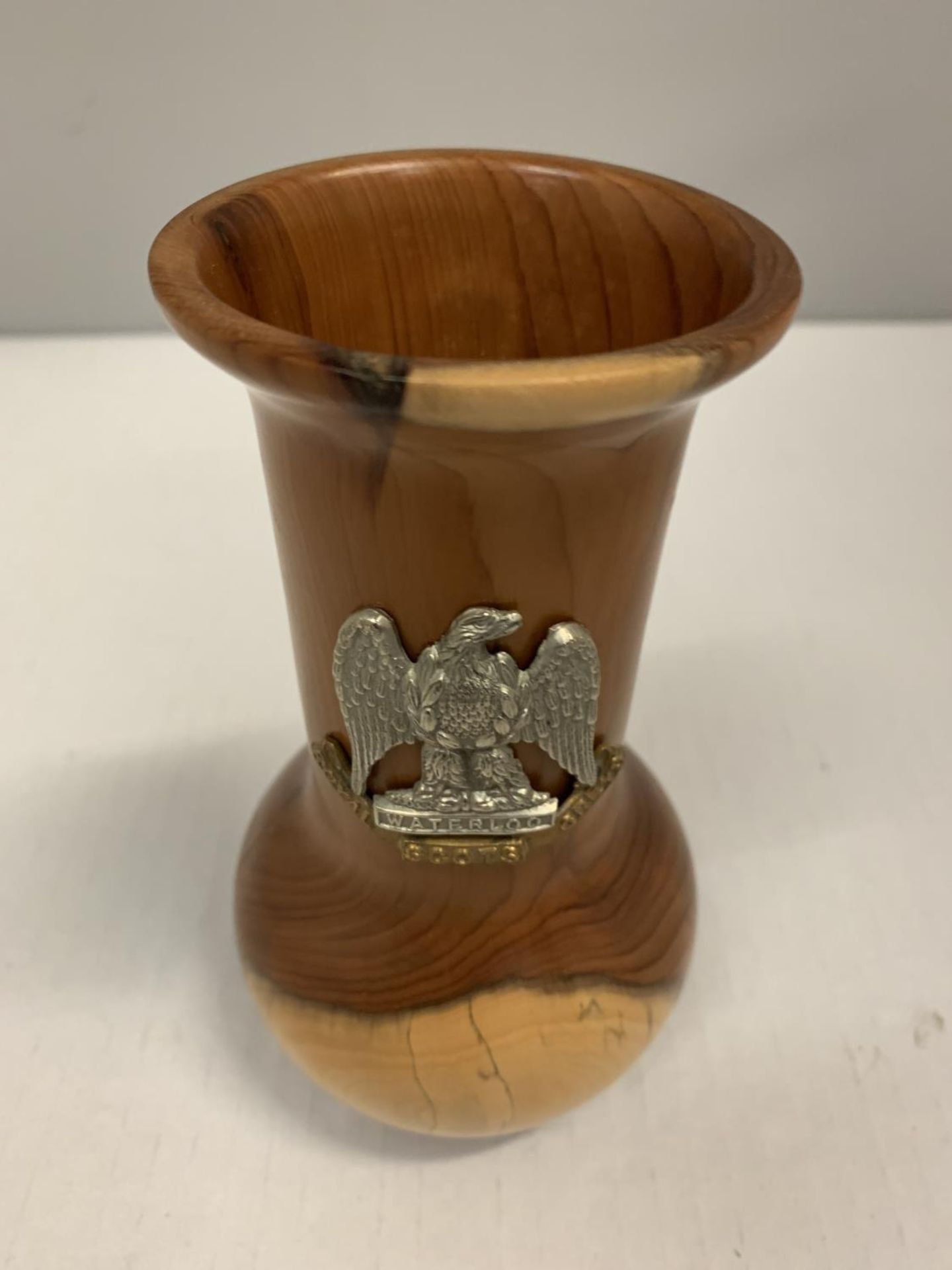 A WOODEN VASE WITH A ROYAL SCOTS GREYS WATERLOO BADGE WITH EAGLE EMBLEM