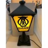 A CAST METAL LAMP WITH "AA GARAGE? THREE SIDED DETAIL TO PANELS AND BELIEVED IN WORKING ORDER BUT NO