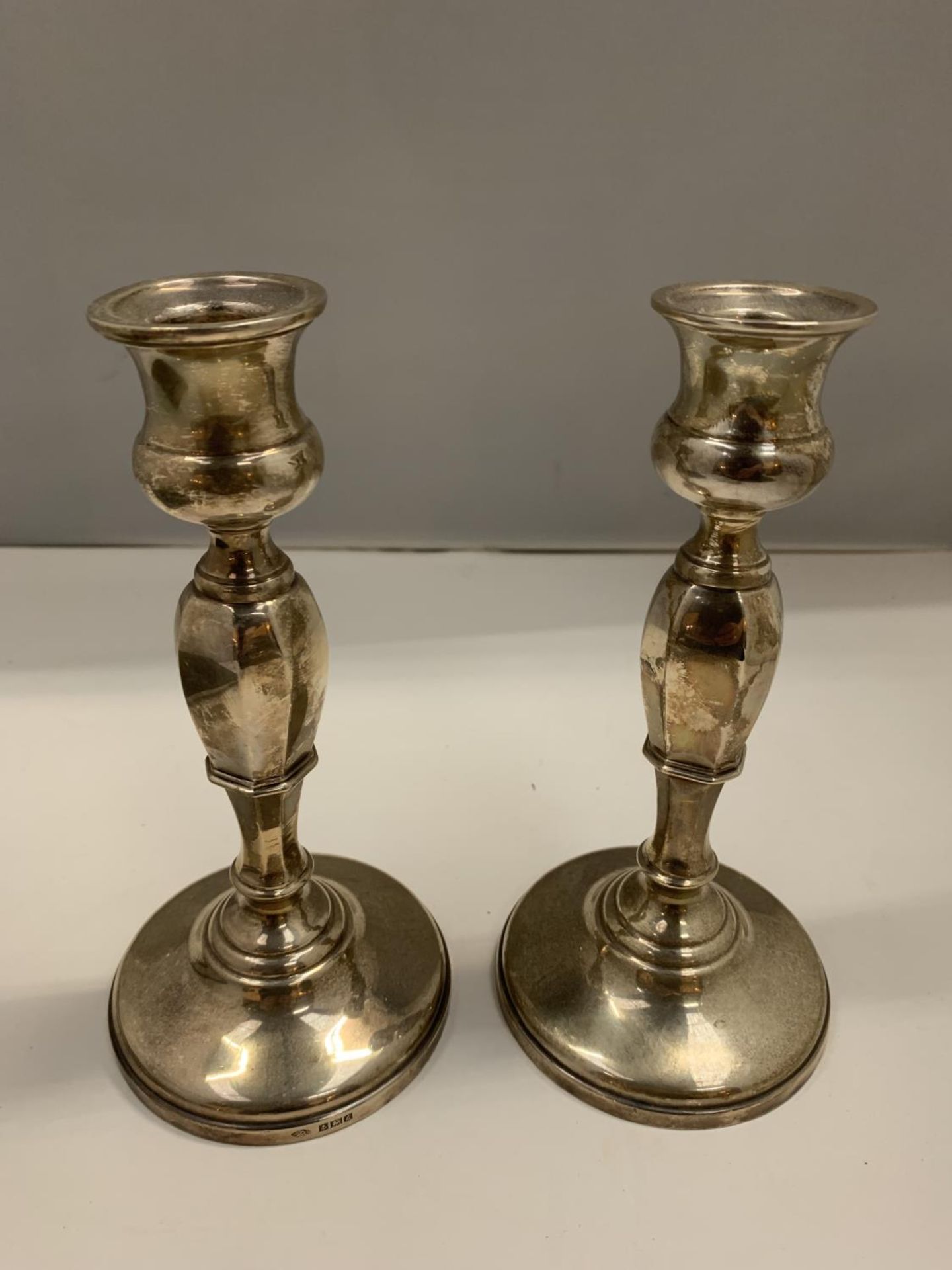 A PAIR OF HALLMARKED BIRMINGHAM SILVER WEIGHTED CANDLESTICKS 18CM TALL