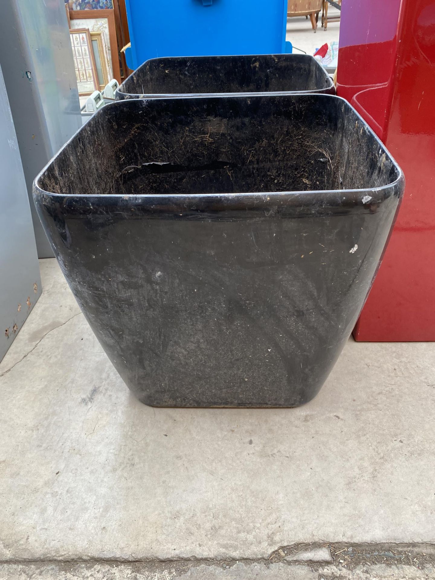 A PAIR OF SQUARE BLACK FIBRE GLASS PLANTERS (H:46CM) AND A FURTHER TALL RED FIBRE GLASS PLANTER (H: - Image 3 of 4