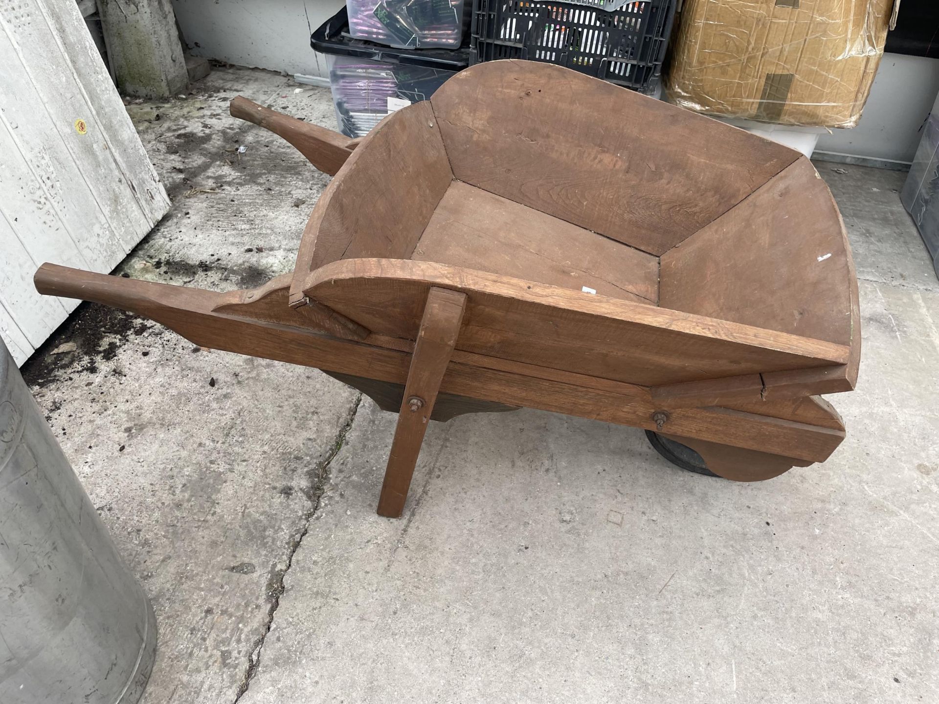 A WOODEN WHEEL BARROW PLANTER CREATED FROM YEW WOOD