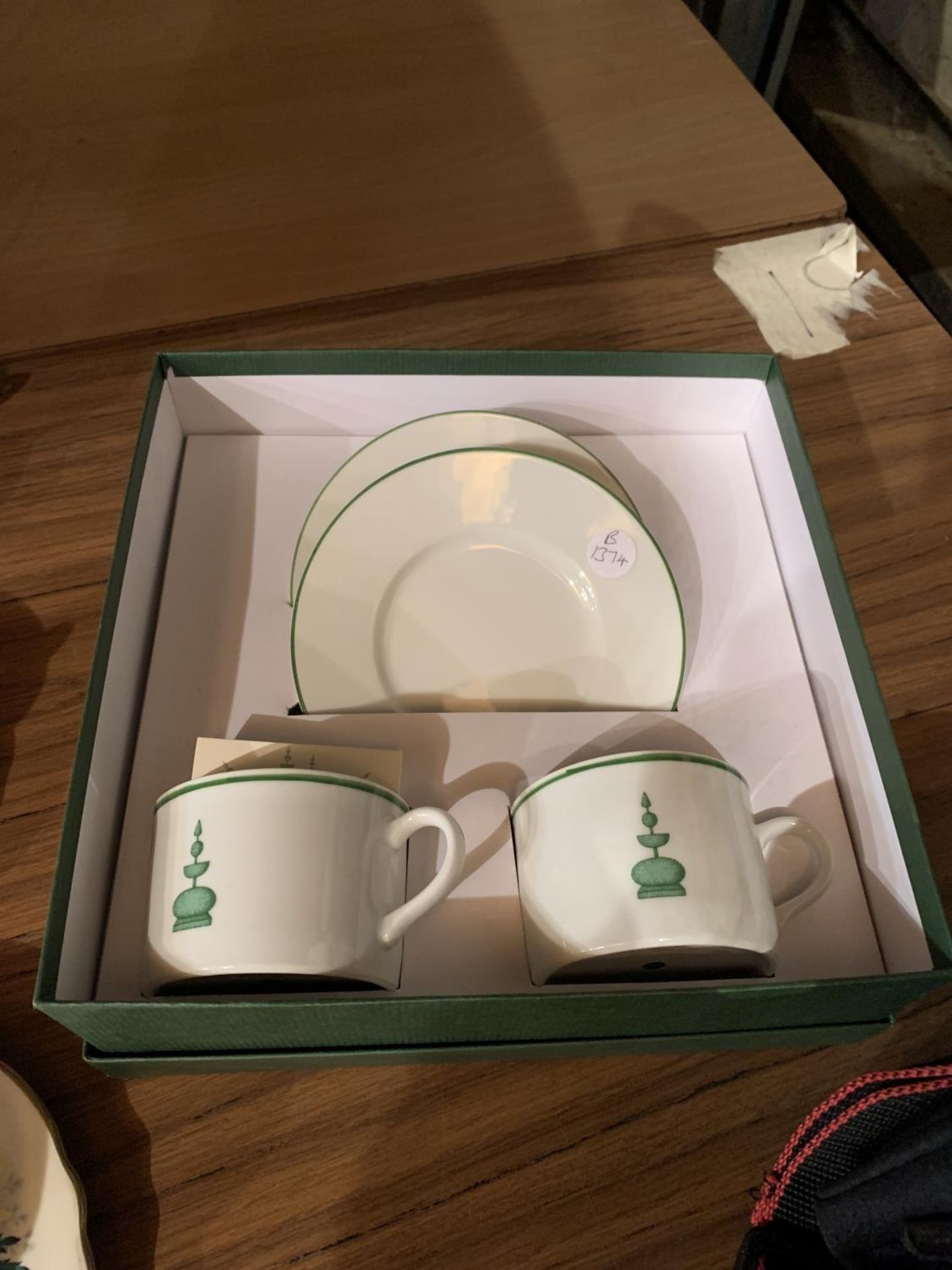 A NEW AND BOXED SET OF TWO CUPS AND SAUCERS WITH TOPIARY DESIGN